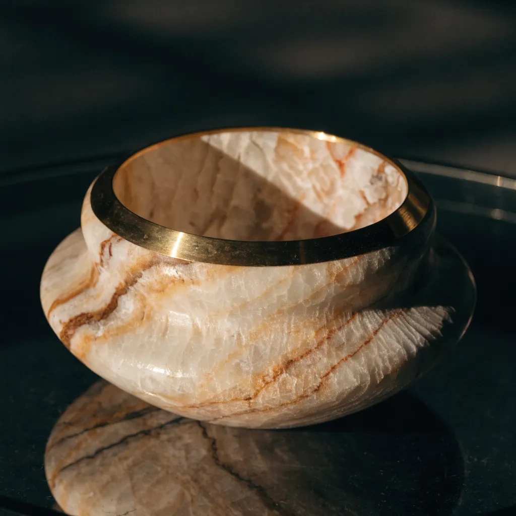 Close-up of a polished marble bowl with a brass rim