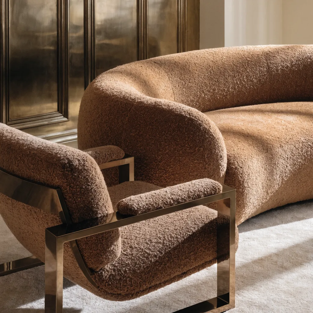 Curved boucle sofa and armchair with polished brass legs
